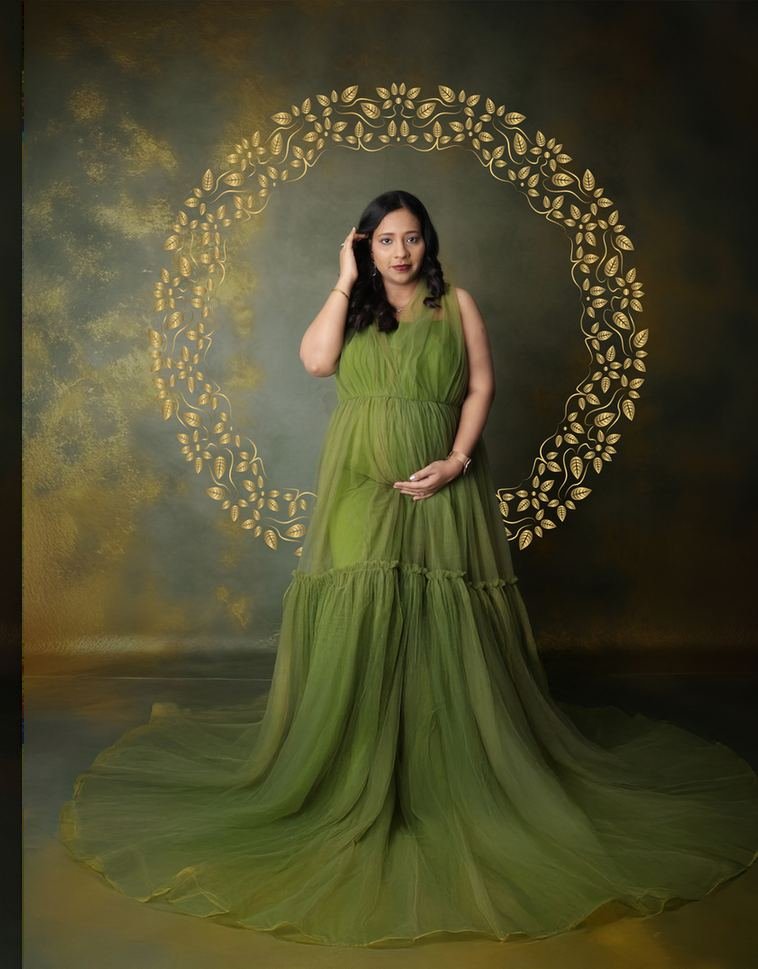 Maternity portrait in an olive gown against a textured backdrop