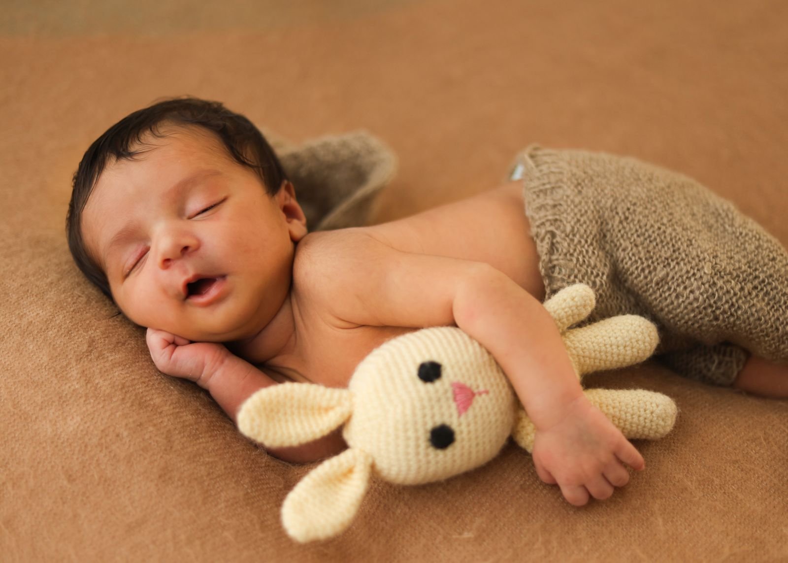 Sleeping newborn with a bunny toy