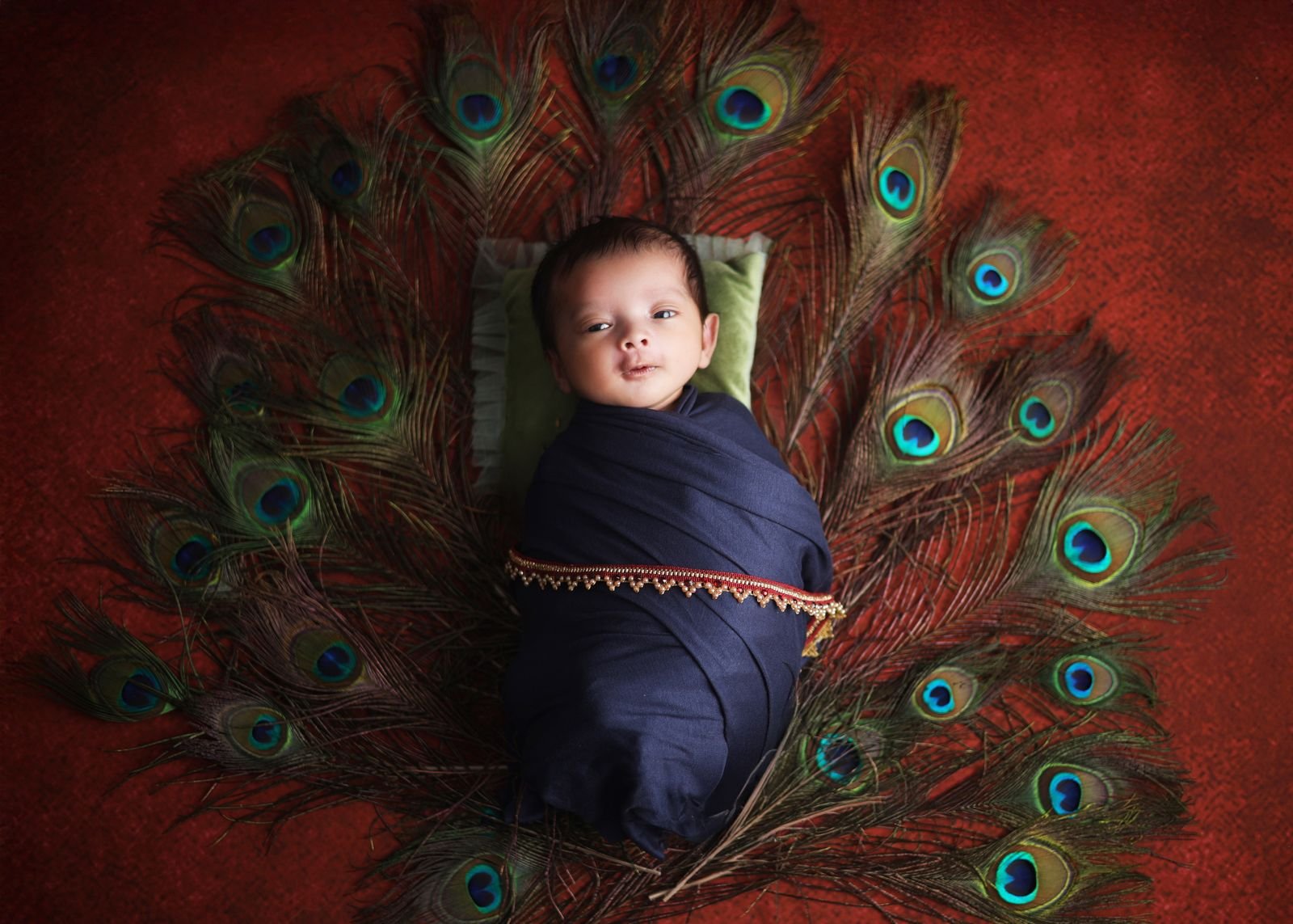 Newborn with peacock feathers
