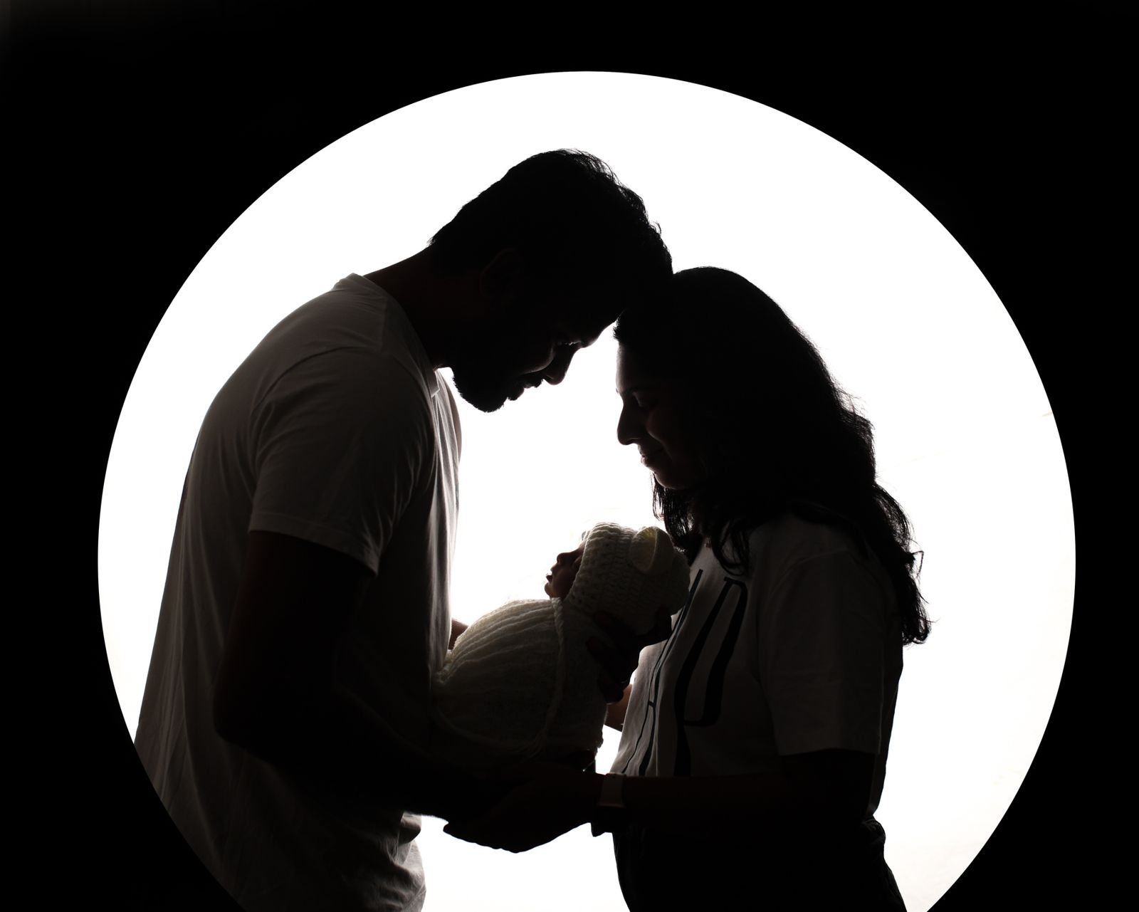 Silhouette of parents with their newborn